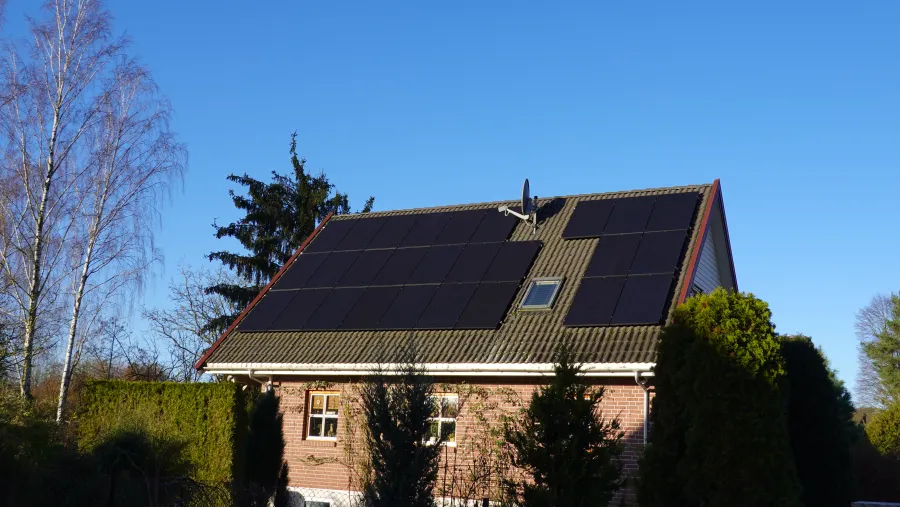 Einfamilienhaus mit Photovoltaikanlage bei klarem Himmel