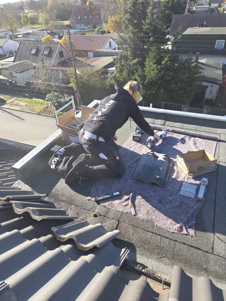 Arbeit an Dachdurchdringung und Befestigung einer Photovoltaikanlage